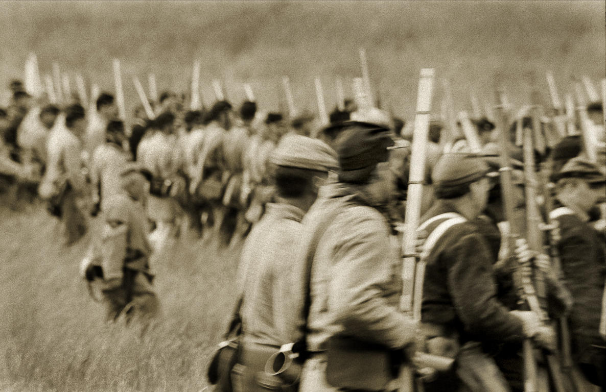 Civil War reenactors in a Confederate battle line moves in a snake-like formation toward Union reenactors at the New Market Battlefield State Historical Park in Virginia.

