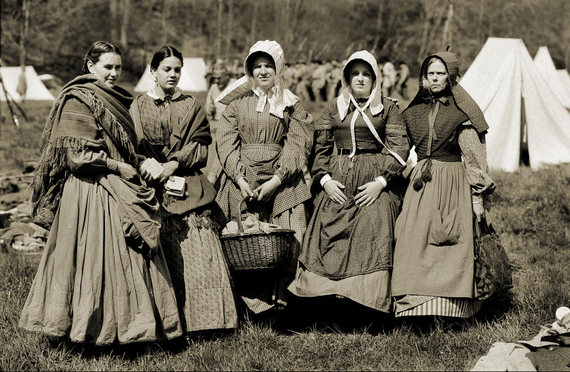 Southern women, wearing utilitarian work clothes and aprons, provide food for soldiers at a reenactment of the Civil War battle of McDowell, Virginia on the real McDowell Battlefield in Virginia.