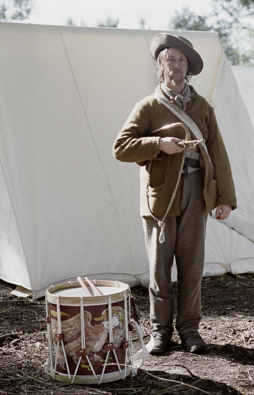 A Civil War reenactor's impression of a bugler with a Union militia unit stands with his instrument tucked under his arm at the 150th anniversary of the Civil War Battle of Wilsons Creek in Missouri.